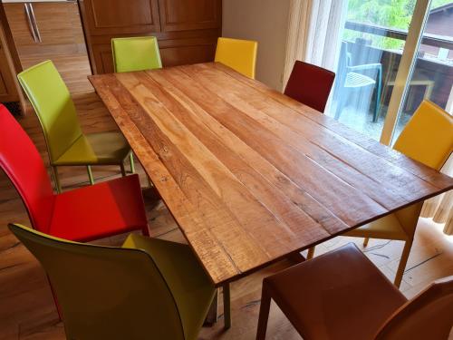 a conference room with a wooden table and colorful chairs at Der Kristall by Globalimmoservice in Bad Kleinkirchheim