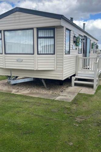 a white caravan with a bench in a yard at Browns caravan rentals, 8 berth, the chase, ingoldmells in Skegness