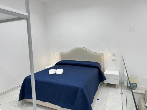 ein Schlafzimmer mit einem blauen Bett mit zwei Handtüchern darauf in der Unterkunft Ziro Suite Luxury House in Amalfi