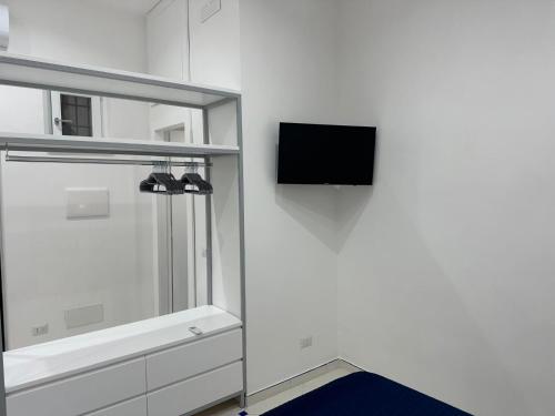 a white room with a tv on a wall at Ziro Suite Luxury House in Amalfi
