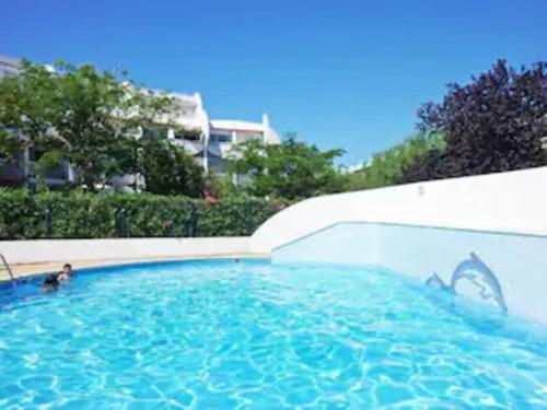 - une piscine avec une personne dans l'eau dans l'établissement Studio cabine moderne design avec vu sur jardin , piscine, à La Grande Motte
