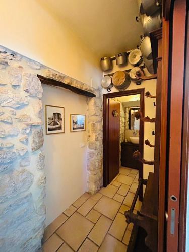 a hallway with a stone wall with pots and pans at Agriturismo Masseria Pozzo in Sperlonga