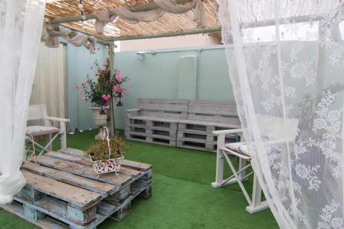 a room with a bench and a table with flowers at la coccinella in Marina di Pisa