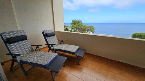 two chairs sitting on a balcony looking out at the ocean at Tenerife Lizards - apartment in the first line in Callao Salvaje