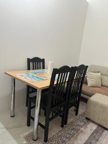 a dining room table with two chairs and a couch at Kompleksi Tre Shqiponjat in Velipojë