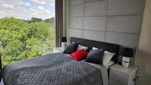 a bedroom with a bed with a large window at YOUR Apartment Unia Art Residence in Lublin