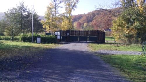 a driveway with a gate in a park at Chalet Domaine du Hulobiet in Fromelennes
