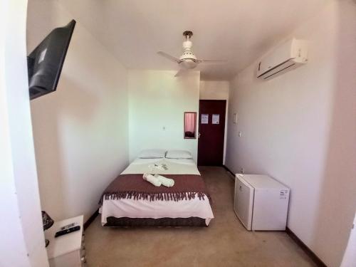 a small bedroom with a bed in a room at Pousada Pé Na Areia in Arraial do Cabo