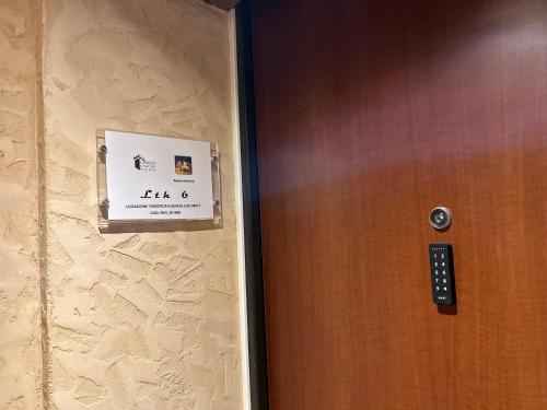 a door with a sign on it next to a wall at Larocca Tourist Home 6 Valbrenta in Carpane