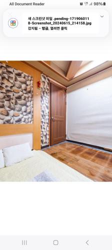 ソンナムにあるCity Park Motelのベッドと石の壁のある寝室