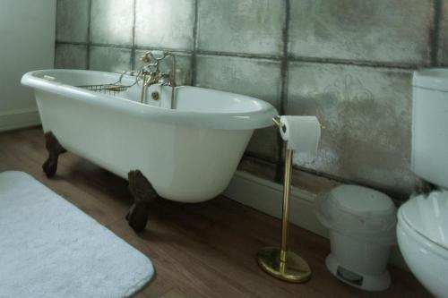 
a bath tub sitting next to a toilet in a bathroom at Meifod House in Caernarfon
