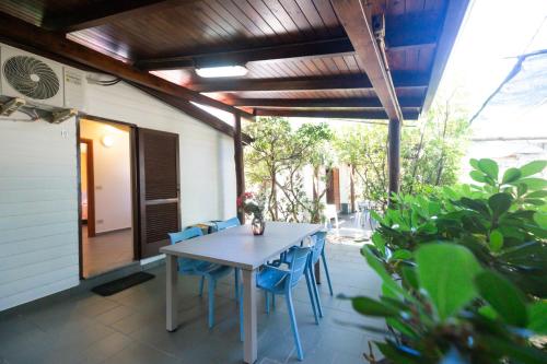 a patio with a table and chairs on a porch at Villaggio Camping Fiorina in Capo Vaticano