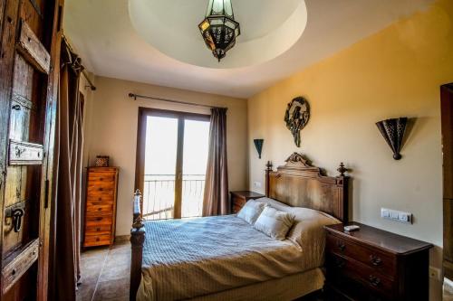 ein Schlafzimmer mit einem Bett mit einer Kommode und einem Fenster in der Unterkunft Casa Disa in Turre