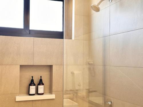 two bottles of wine sitting on a shelf in a bathroom at Levitat Hunah in Playa del Carmen