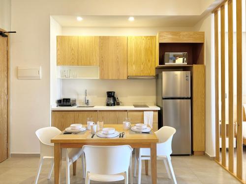 a kitchen with a wooden table and white chairs at Levitat Hunah in Playa del Carmen