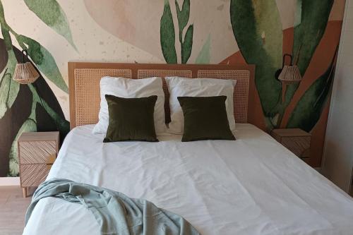une chambre avec un lit avec des draps blancs et des oreillers dans l'établissement T2 terrasse arborée vue mer, à Hyères