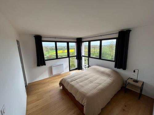 - une chambre avec un lit et quelques fenêtres dans l'établissement Maison moderne du Perche - Bienvenue chez Aurélie, à Laleu