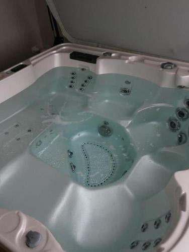 La salle de bains est pourvue d'une baignoire remplie d'eau. dans l'établissement Maison moderne du Perche - Bienvenue chez Aurélie, à Laleu