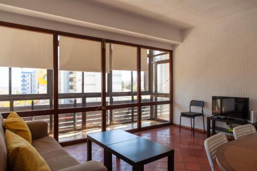 a living room with a couch and a table and a tv at T3 Casa Central in Sesimbra