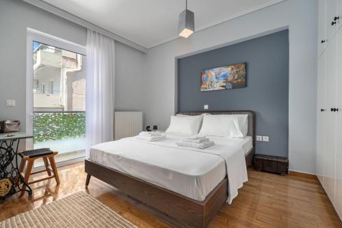 a bedroom with a large white bed and a window at Luxurious Coastal Retreat in Central Glyfada in Athens