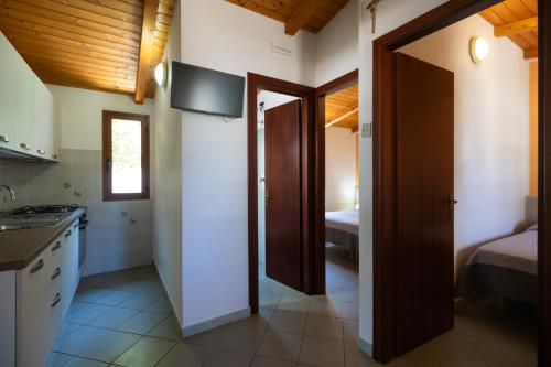 a kitchen with a door leading to a bedroom at Villaggio Camping Fiorina in Capo Vaticano