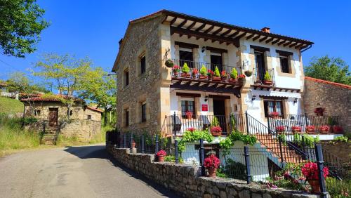 a building with flower boxes and balconies on a street at Casa de la Fuente Santillana del Mar in Santillana del Mar