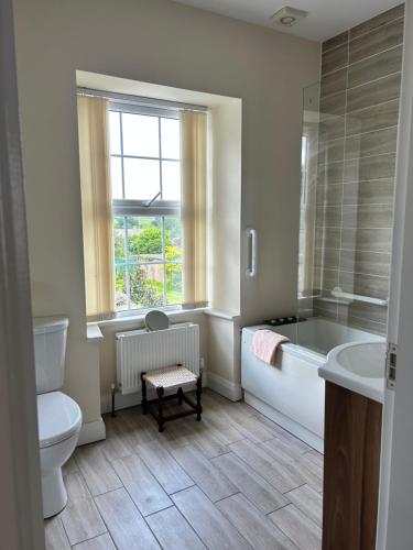 ein Badezimmer mit Badewanne, Toilette und Waschbecken in der Unterkunft Wee Betty’s Cottage in Caledon