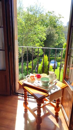 a table with dishes on it on a balcony at Casa de la Fuente Santillana del Mar in Santillana del Mar