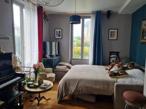 ein Schlafzimmer mit einem Bett und einem Klavier in der Unterkunft Artist house with piano and charming garden in Reims