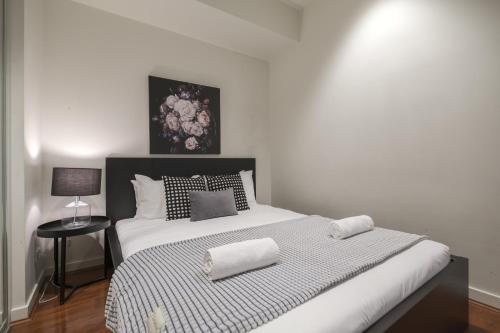墨尔本Nice View 2br Apt At William St Pool Gym Balcony的卧室配有一张带两个枕头的大白色床