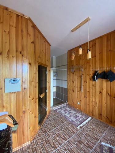 a bathroom with wood paneled walls and a shower at Opushka in Vorobʼyëvka