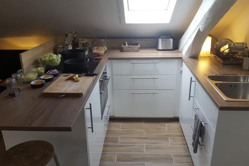une cuisine avec des armoires blanches et un comptoir en bois dans l'établissement Studio cosy au calme à Meudon, à Meudon