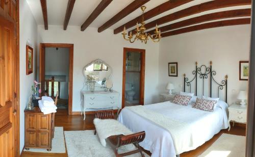 a bedroom with a white bed and a chair at Casa de la Fuente Santillana del Mar in Santillana del Mar