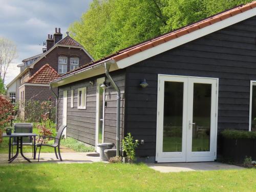 a black house with a bench in front of it at Halte Liempde Logies in Liempde