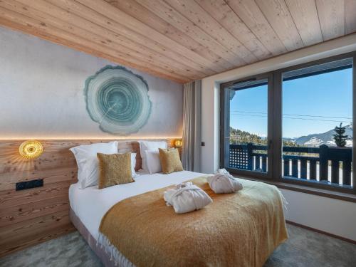 une chambre avec un lit avec deux serviettes dessus dans l'établissement Courchevel 1850: Appartement neuf au pied des pistes avec piscine et SPA - FR-1-564-102, à Courchevel