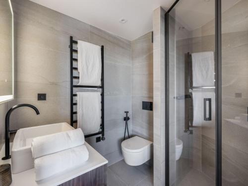 une salle de bain avec un lavabo, des toilettes et une douche dans l'établissement Courchevel 1850: Appartement neuf au pied des pistes avec piscine et SPA - FR-1-564-102, à Courchevel