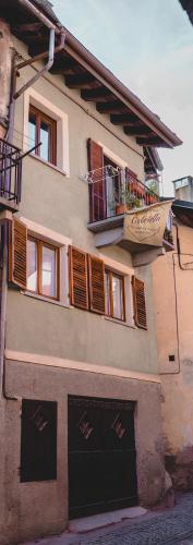 a building with two garage doors and a balcony at Bed & Breakfast Gabriella EXILLES in Exilles