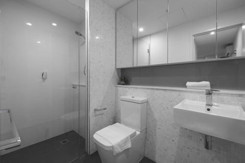 a bathroom with a toilet and a sink and a shower at Exquisite And Warm 1br Nest In Footscray Pool Gym in Melbourne