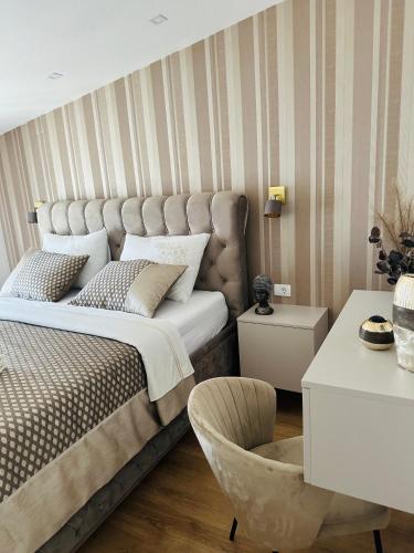 a bedroom with a large bed and a chair at VILLA PADRE in Podstrana