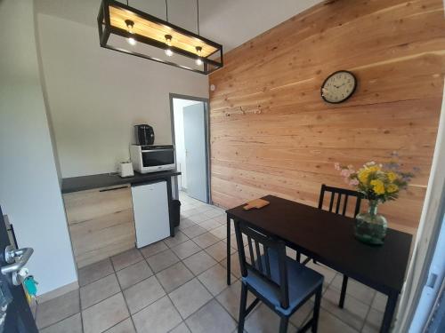 a kitchen and dining room with a table and a clock at gite de la fontaine in Olby