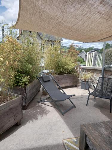 a chair sitting under an umbrella on a patio at Le 28 in Uzerche