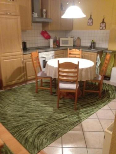 a kitchen with a table and chairs on a rug at Ferienhaus 1 in Michaelstein