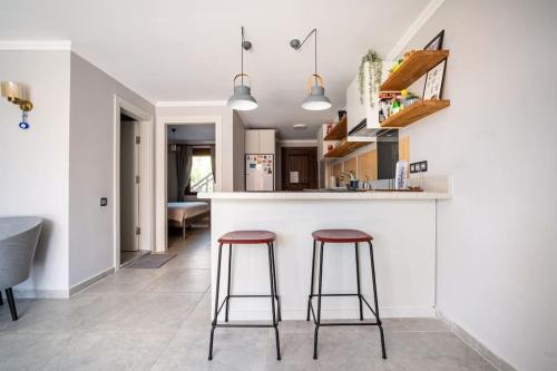 a kitchen with two bar stools at a counter at Kalkan lovely 1 bedroom holiday rental in Kas