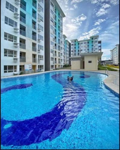 a large pool with blue water in front of a building at Urban Charms Seawind Condo, 5 mins to Davao Int'l Airport and Wharf to Samal Beach in Davao City