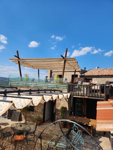 a building with a patio with tables and chairs at Assos Sunset Hotel in Behramkale