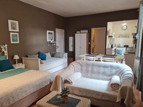 une chambre avec deux lits et un salon dans l'établissement LE PRIEURE - STUDIOS jusqu'à 4 personnes, à Villeneuve-lès-Béziers