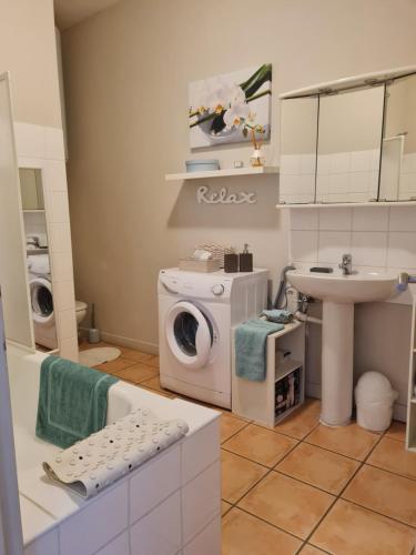 ヴィルヌーヴ・レ・ベジエにあるLE PRIEURE - STUDIOS jusqu'à 4 personnesの洗濯機と洗面台を備えたバスルーム