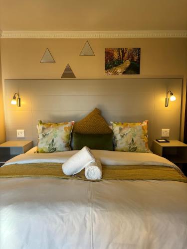 a bedroom with a large white bed with two pillows at Accommodation Bedfordview - Hethersett Guesthouse in Johannesburg
