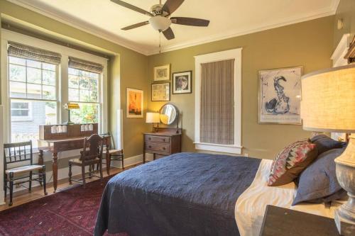 a bedroom with a bed with a ceiling fan and a desk at Midtown Central Gardens Bungalow in Memphis