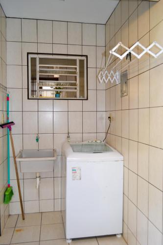 a bathroom with a white refrigerator and a sink at Casa Charmosa e Aconchegante em Serra Negra - SP in Serra Negra